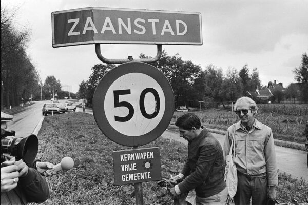 Waarom Nederlandse gemeenten zich internationaal opnieuw moeten uitvinden: in gesprek met Dion van den Berg — Wethouder Nieuwenhuizen (l) onthult in 1982 de gemeente Zaanstad, als eerste gemeente, een bordje “Kernwapenvrije gemeente”. Rechts Nico Schouten van het actiecomité Stop de Neutronenbom.